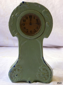 Small green coloured ceramic clock case with gold-tan clock face
