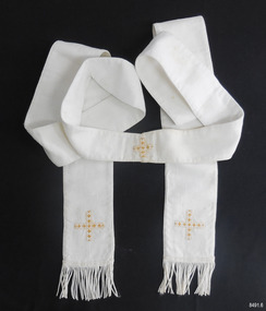 Long rectangle of white coarse fabric. Ends slightly flared and decorated with fringe. Embellished with crosses