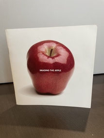 Small white booklet with photograph of red apple on cover