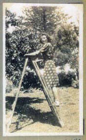 Photograph of woman on stepladder