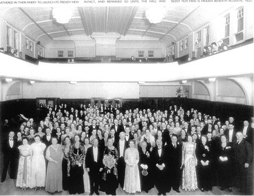 Photo shows a large group of people in formal dressing attending a social function. 