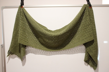 Olive green, loose weave cotton material scarf, ragged at both ends.