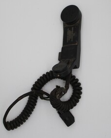 Black plastic telephone-style handset with coiled wire and plug. has a rounded mouthpiece and earpiece at each end of a curved handle.