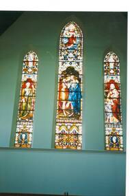 Three tall, gothic stained glass windows, centre taller, showing biblical figures.