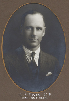 Black and white photograph of an oval portrait of a man in a pin-striped suit