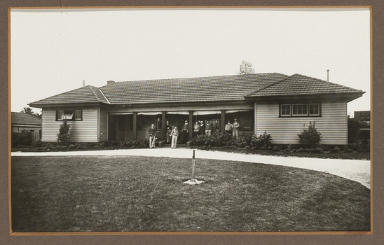 Black and white photograph of golfers in front of a sporting club house