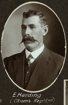 Black and white oval photograph of a man in a suit with his name written underneath on the mount