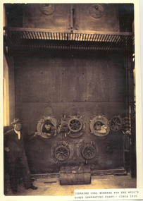 Photograph, Cleaning coal bunkers for the mill's power generating plant -circa 1925