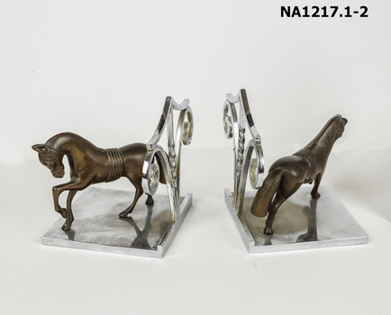 Metal book ends with copper horses standing on base. 