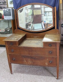 Wooden dresser with a mirror, two small drawere and two large drawers with circular recessed metal handles.