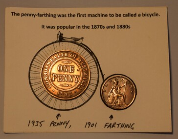 Australian penny and farthing coins attached to a card depicting a penny farthing bicycle.