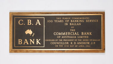 A large, heavy brass commemorative plaque mounted on a timber backing.