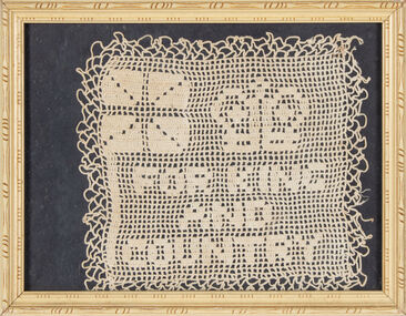 A doily crochet in cotton, mounted on a black background, placed under glass in a cream coloured timber frame.