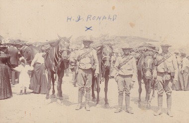 Three soldiers and three horses facing towards camera. Civilians standing in background.Text "H.G Ronald" written on image.