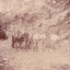 Seven miners and a horse and cart are depicted in front of mine a dug out hill. Five men stand alongside the horse facing the camera,  one man sits up the hill with a dog, and a final man stands higher. Six of the men lean against a pick or shovel, and six wear hats.  Broken rocks from the cliff are depicted strewn around the ground. 