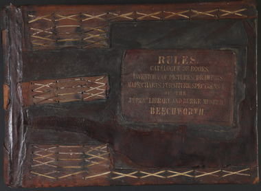 The front cover of a brown leather bound book with embossed gold lettering 