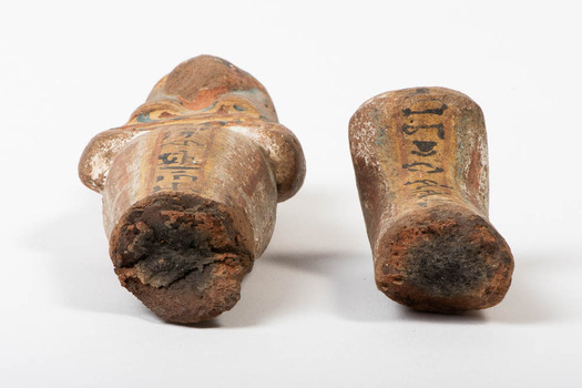 Closeup of the damage to the centre of Ushabti. Both parts (upper and lower) are separated through a break in the centre of the figure and are placed beside each other. 