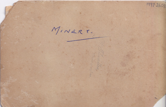 Reverse of a photograph. Paper is light brown and the word "MINERS" is written in blue ink in the center of the image. "W. Thwaites Photography" is written vertically on the paper slightly under the word "MINERS"