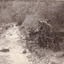 River flowing through scrub towards a metal wheel; part of a mine set up. (cropped)