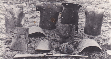 A postcard depicting 10 pieces of Kelly Gang armour and gun, including breast plates and helmets.