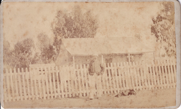 Sepia photograph of an unidentified policeman and a dog outside the Glenrowan Police Station