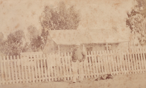 Sepia photograph of an unidentified policeman and a dog outside the Glenrowan Police Station