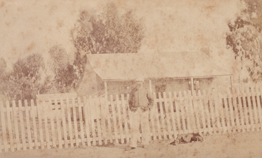Sepia photograph of an unidentified policeman and a dog outside the Glenrowan Police Station