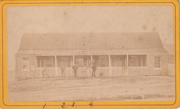 Image of Glenrowan police station on 1 August 1882 with four men standing/sitting out front.