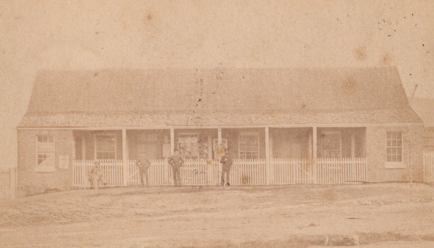 Image of Glenrowan police station on 1 August 1882 with four men standing/sitting out front.