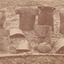 Sepia photograph of Kelly armour including helmets and breastplates arranged on the ground.
