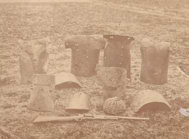Sepia photograph of the Kelly Gang armour sitting on the ground. 