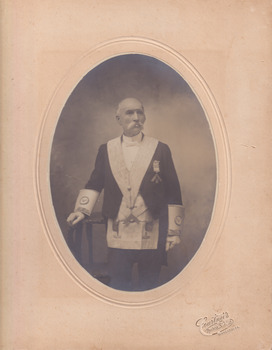 The portrait of the older man in uniform, with a handlebar moustache, in an oval frame. The words Courtnei's Thelma Studios is on the bottom right hand corner of the photo frame