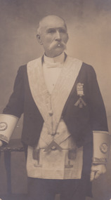 A portrait of a man, who is older in age. He is in uniform and has a handlebar moustache.