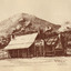 At the foreground of the photo is an inn (made up go 2 houses), surrounded by trees with a large mountain in the background