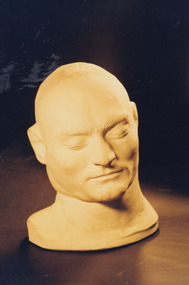 Colour photograph of Ned Kelly’s death mask showing details of the front of his face. The mask is life size and made of plaster.
