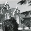 Group of buildings close together - gardens in front. On one building is a sign over the door: "Ovens & Murray Home"