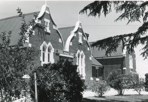 Group of buildings close together - gardens in front. On one building is a sign over the door: "Ovens & Murray Home"