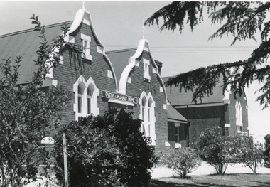 Group of buildings close together - gardens in front. On one building is a sign over the door: "Ovens & Murray Home"