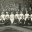 Photograph of mental hospital staff, nurses and male workers. 16 men in 2 rows, with a row of female nurses in between. 2 men in the photo have 'Kepi' style hats.