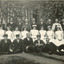 Photograph of mental hospital staff, nurses and male workers. 17 men in 2 rows, with a row of female nurses in between. 2 men in the photo have 'Kepi' style hats.