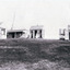 Black and white copy of a photograph depicting weatherboard dwellings, nurses and water tanks