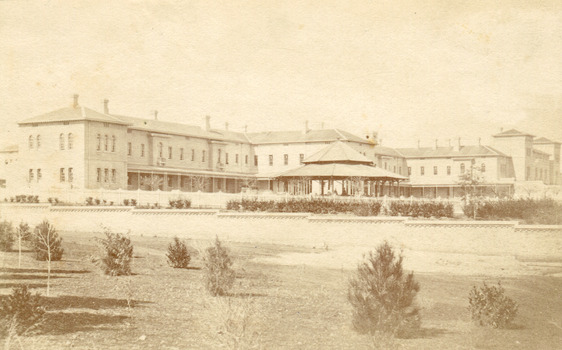 A black and white photograph featuring the exterior of the Beechworth Mental Asylum buildings.