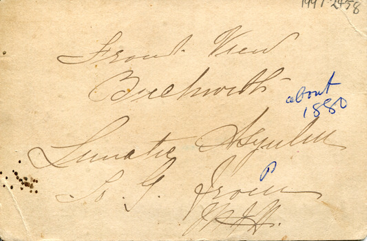On the back of the photograph where a child sitting in a horse drawn carriage surrounded by eight people in front of the Beechworth Mental Asylum's administration building is original details about location and date of the photograph including a signature  