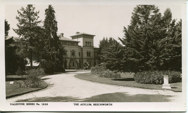 A sand pathway featuring manicured gardens on either side leading towards the Beechworth Mental Asylum administration building 