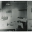 Grainy black and white photograph showing interior of surgery and consulting room in the Mental Hospital. Tables with medical instruments, bowls and jars are visible. Lefthand section of the photograph has been reproduced on the righthand side to show details which are lost due to overexposure. 