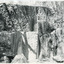 Rock face of a quarry, rock in the centre of the image has been marked at intervals in a vertical line. 