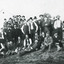 Black and white photograph of a large group of men, most with moustaches and wearing hats, stand together in front of a gabled building (Allen's or Kerferd's brewery?). Some of the men are seated or reclining on the grassy crest of the hill, two seated and one standing men carry large shears/clippers in their right hands. On the left of the photo, two standing men wear aprons.