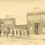 Six men and a boy stand outside of three buildings. The man furthest to the left is mounted on a horse, the next leftmost man holds the leadrope to another horse. The buildings have signs on them that read (from closest to furthest) "J. Duncan / Straughair and Duncan / Beechworth Foundry" "J. Duncan / Straughair and Duncan / Engineers Blacksmiths and Farriers" "Duncan's Coach Factory" 