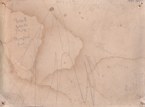 Rear of the aged photograph. Colour is tan with some water stains and dark age spots visible. Scribbled writing is visible. 