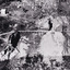 A black and white photograph taken from a high angle of rough terrain on the Rocky Mountain Mine. There is stone rubble spread across the landscape as well as mining equipment such as a vertical conveyor belt.